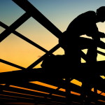 Builders are building a wooden house.